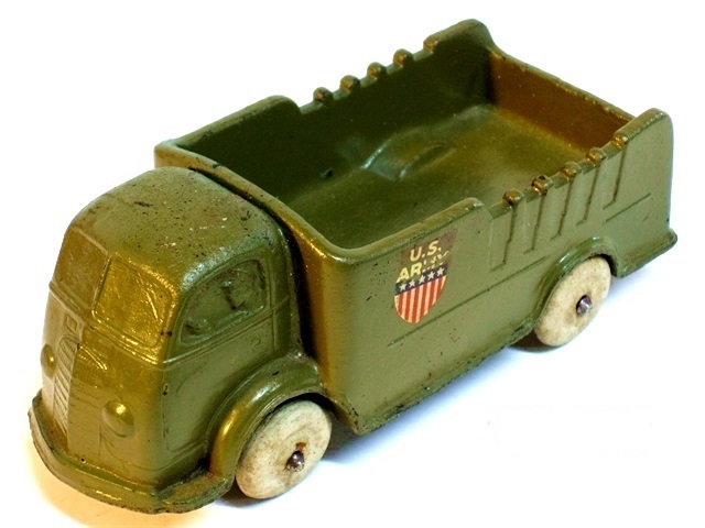 With olive paint and a red, white, and blue shield shaped decal, the '37 cabover becomes an army truck. U.S. Army is above the shield in white, which has five white stars against a blue background at the top of the shield and alternating 6 red and 7 white vertical bars below.