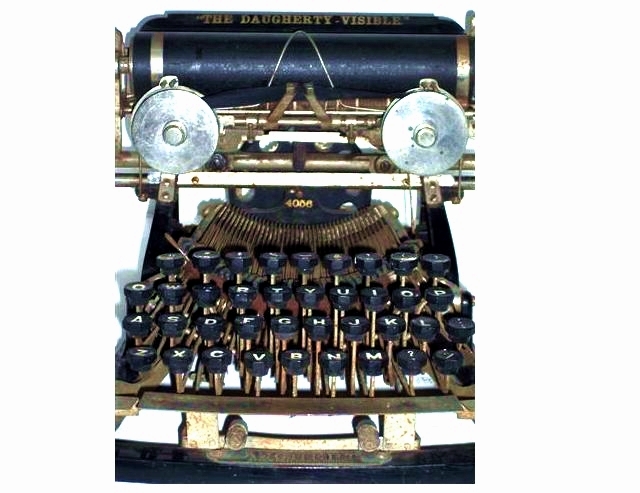 This is a view from the front, just a bit above head-on. The most striking feature from this angle is the pair of ribbon spools, nickel plated and with their tops facing the typist. It is kind of startling. 