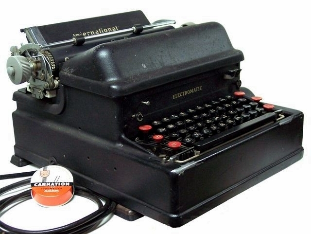 Seen from the left, the modern lines of the typewriter, its crinkle finish, and the traditional paper tray and carriage make an appealing package.