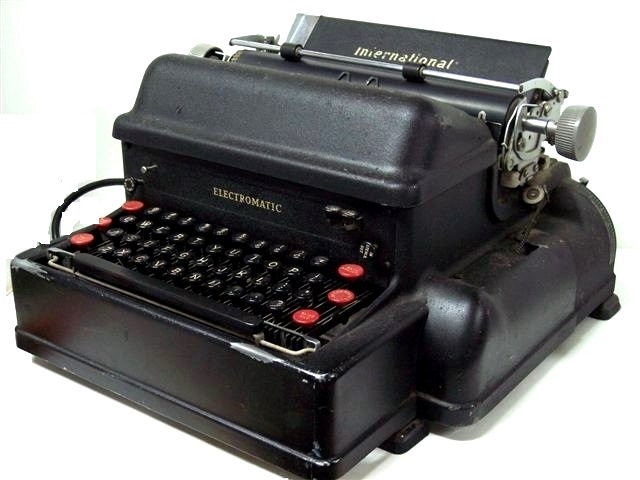 From the right, the look is even more traditional with the paper tray, carriage, platen and twirlers, and paper bail reassuring the uninitiated that all is well. The logo, International, appears in large letters on the paper tray, and the label, Electromatic, appears on the front of the machine just above the keyboard. The three red keys on each side of the keyboard, the grey plastic platen twirlers, and the brightwork all are set off handsomely by the shining paint.