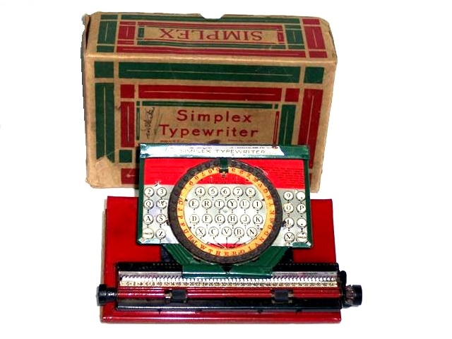 It will take some doing to describe this Simplex, which I have called the pizza since first seeing it. It is a metal machine on a wood base stained dark red. The index disk is large and designed to look like it is see-through to the keys beneath it. The toy is pained in red, white and green, with a broad horizontal band of red across the top, white in the middle with the faux keys, and the green metal parts are dark green - rather like the flag of Italy. Or Mexico. But I choose Italy and call it the pizza. The disk is a tan circle with red upper case letters and figures.
