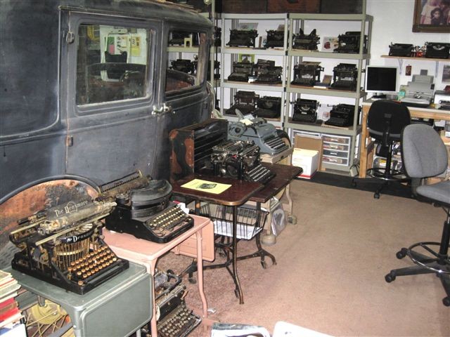 Today, all seen below has changed or gone. In its place is a single workstand with adjacent file cabinet on one side and four-shelf unit. The single computer, a very small box, a printer and a scanner, and a wall-mounted monitor comprise the museum's computing tools. The displays, toys, Mexican movie posters and airplanes remain.