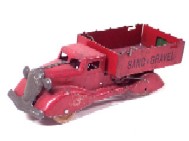 A ten inch Barclay auto carrier with cast metal red cab and silver stamped metal trailer. The trailer has one lever and is carrying two small diecast metal cars, one blue and one green.